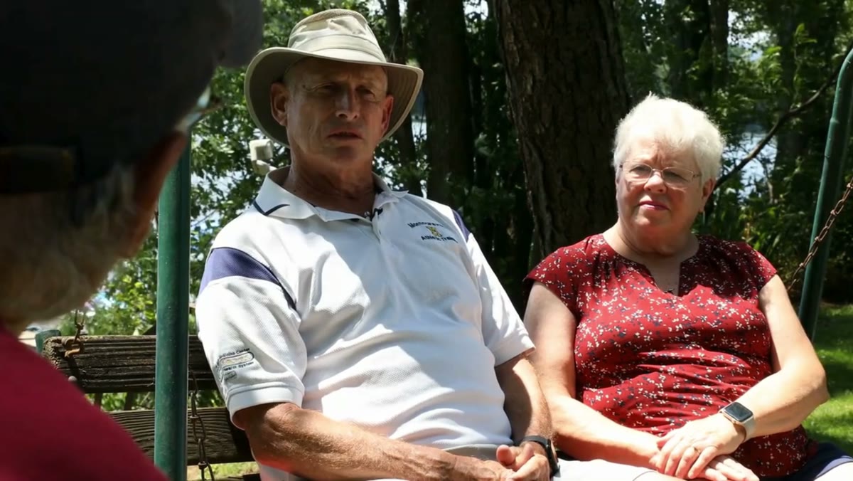 A couple on a porch swing being interviewed for their family film