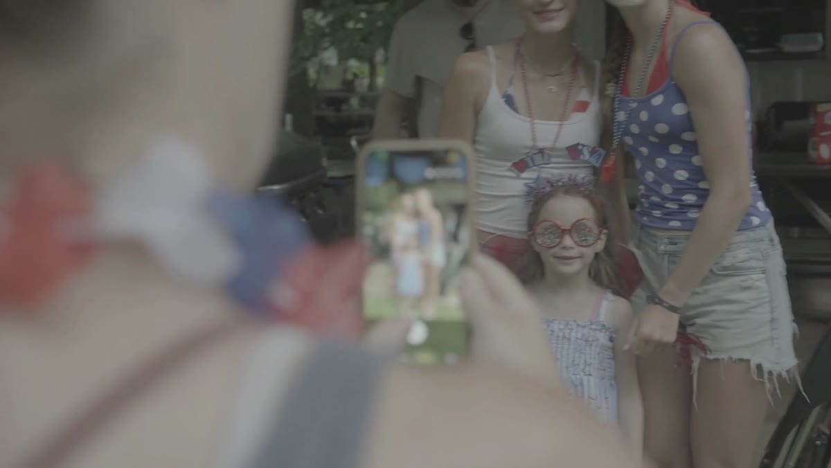 A family member showing a photograph on her phone at a reunion